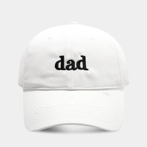 Detailed view of the black 'dad' embroidery on a white cotton baseball cap with curved brim