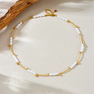 French vintage oval pearl and gold bead stainless steel necklace on a textured background