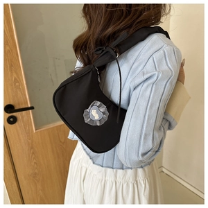 Detail of black nylon hobo bag with white lace heart patch and cartoon animal design