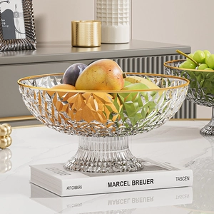 Macro shot of crystal fruit bowl with gold rim and geometric texture on art book