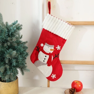 Detail of embroidered snowman Christmas stocking hanging on a rustic wooden ladder