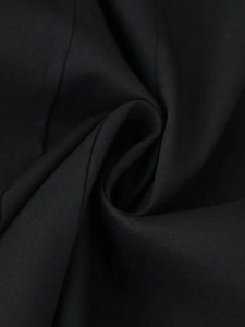 Dettaglio ravvicinato del tessuto nero dell'abito blazer che mostra la trama liscia e fine