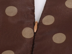 Close-up of invisible zipper detail on brown polka dot organza midi dress fabric