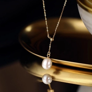 Elegant Y-shaped necklace with a lustrous white freshwater pearl on a golden metal chain