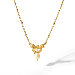 Collana in oro 18 carati con ciondolo a farfalla e perla su sfondo bianco