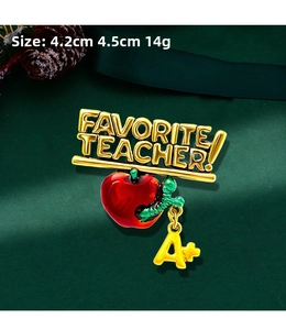 Detailed macro view of a Favorite Teacher apple brooch with an A+ charm and gold text