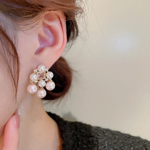 Detailed model shot of gold-plated square zircon earrings with pearl tassels on ear