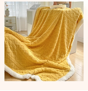 Detail of yellow knit blanket showing 3D textured pattern and white sherpa fleece lining