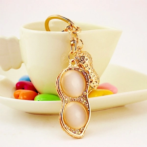 Golden peanut keychain with opal stones and sparkling rhinestones on an elegant background