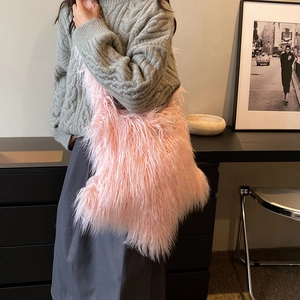 Pink faux fur shoulder bag for women styled with casual knitwear in a modern setting