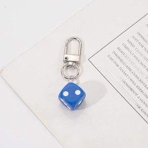 Close-up of a deep blue six-sided dice keychain with a polished silver lobster clasp