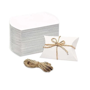 Detail of white pillow-shaped gift boxes with natural jute twine for wedding favors