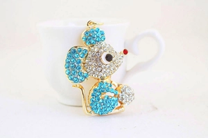 Macro shot of a cute golden mouse keychain with blue rhinestones and a crystal ball