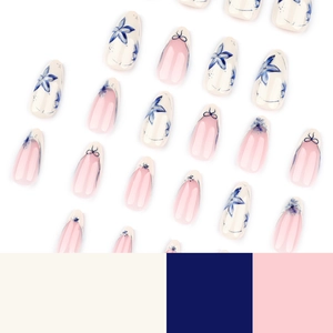 Short almond press-on nails with blue floral designs and french tips with tiny bows