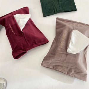Detail of velvet tissue bags with gold happiness embroidery in burgundy and green colors