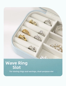 Detail of travel jewelry box featuring wave ring slots and beige velvet lining