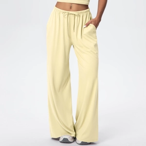 Detail view of elastic waist and drawstring on yellow wide-leg lounge trousers