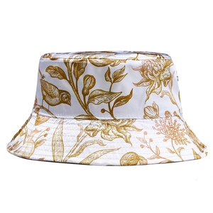 Detail view of satin bucket hat featuring gold floral patterns and metallic eyelets