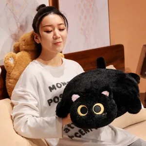 Morbido cuscino in peluche a forma di gatto nero tenuto in una calda camera da letto