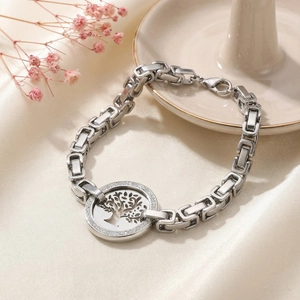 Detailed view of Tree of Life bracelet with pave set crystals on smooth white satin