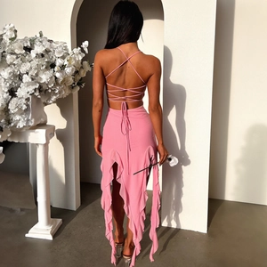 Detail of pink backless summer dress featuring criss-cross lace-up straps and ruffled hem
