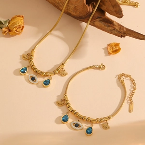 Parure de bijoux dorés avec charmes mauvais œil et pendentifs en cristal bleu goutte