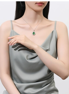 Close-up of S925 silver necklace featuring a teardrop green gemstone with diamond halo