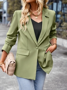 Detail shot of the green short-sleeve blazer featuring a unique patchwork design for women