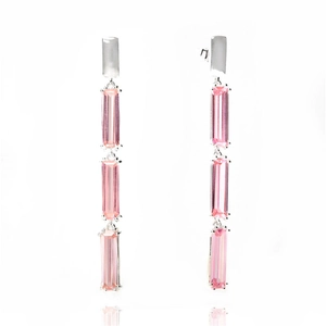 Detail of silver drop earrings featuring triple pink rectangular cut stones and long tassels