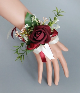 Gros plan d'un corsage de poignet de mariage avec rose en velours bordeaux et rubans