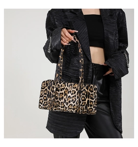 Close-up of leopard print shoulder bag with heart charm and plush texture detail