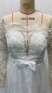 Détail de la broderie en dentelle florale et nœud en satin sur une robe de mariée en tulle