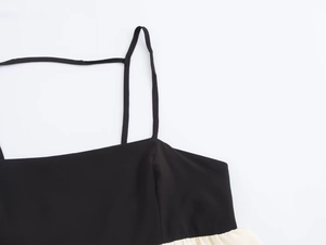Close-up of contrast stitching and straps on black and white backless maxi dress