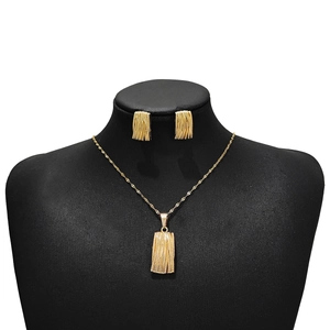 Golden jewelry set featuring square striped necklace and earrings on a black mannequin display