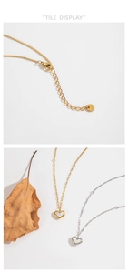 Detail of gold and silver heart shell necklaces with extension chain and brand tag
