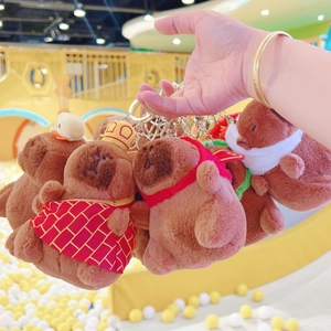 Close-up of cute plush capybara keychains with gold rings and small themed accessories