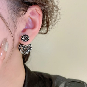 Close-up of vintage hollow geometric silver stud earrings on a female model ear
