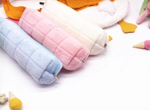 Detailed close-up of colorful plush pencil cases with grid quilting and metal zipper