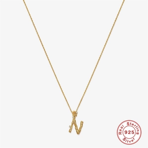 Macro shot of 18K gold plated S925 sterling silver initial N pendant with textured finish