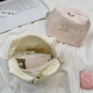 Close-up of floral cosmetic bag with vertical texture and decorative charms