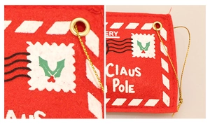 Detailed macro view of red felt Christmas envelope ornament with gold grommet and stitching