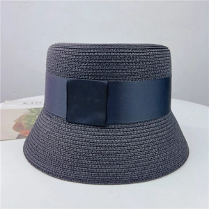 Elegant navy blue woven straw bucket hat featuring a decorative grosgrain ribbon band
