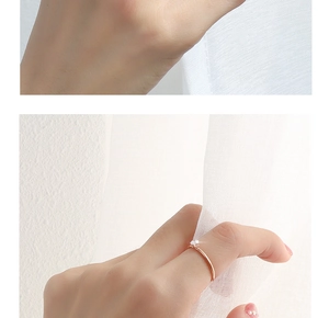 Close-up of minimalist rose gold ring with small embedded gemstone on a hand