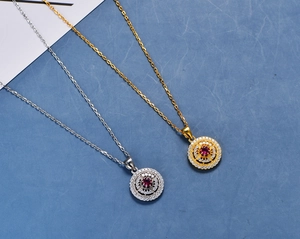 Macro shot of gold and silver necklaces with ruby pendant and micro-set zircons