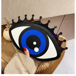 Detail of creative eye-shaped crossbody bag with glitter eyelashes and gold chain