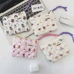 Flat lay of floral quilted pouches with cartoon patterns and colorful zipper cords
