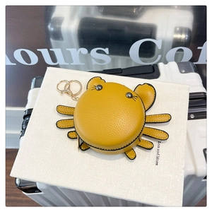 Macro detail of yellow crab coin purse with lychee grain leather and golden keychain