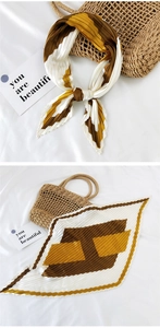 Close-up of pleated silk scarf with geometric color-block design in brown and yellow