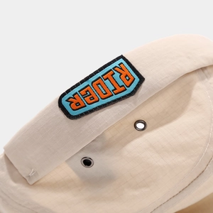Beige quick-dry docker cap with RIDER embroidery and breathable metal eyelets