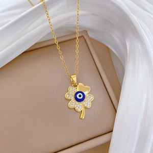 Detail of clover pendant with inlaid evil eye and sparkling crystals on golden chain